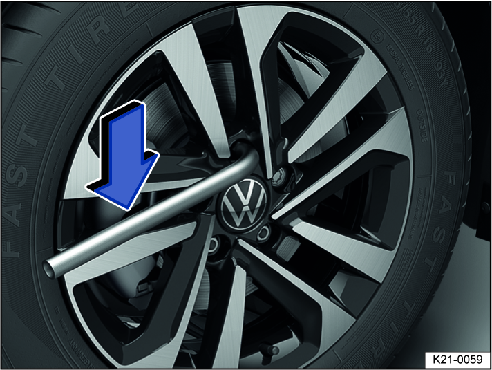 Fig. 201 Changing a tire: loosening the wheel bolts.